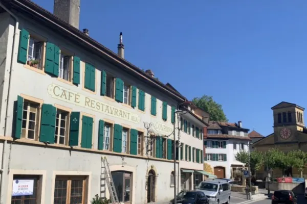 Ancien café-restaurant aux fenêtres sans volets, une échelle contre le mur