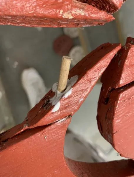Angle d’un volet rouge rechevillé avec un tourillon de bois