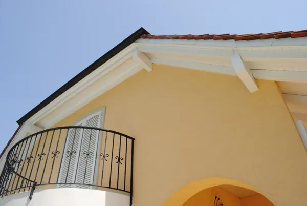 Balcon et rive en bois remis en peinture sur une maison claire