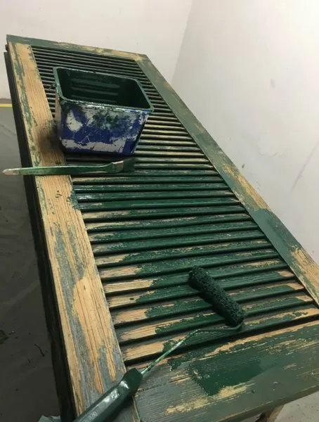 Volet à lames moitié bois nu, moitié repeint en vert