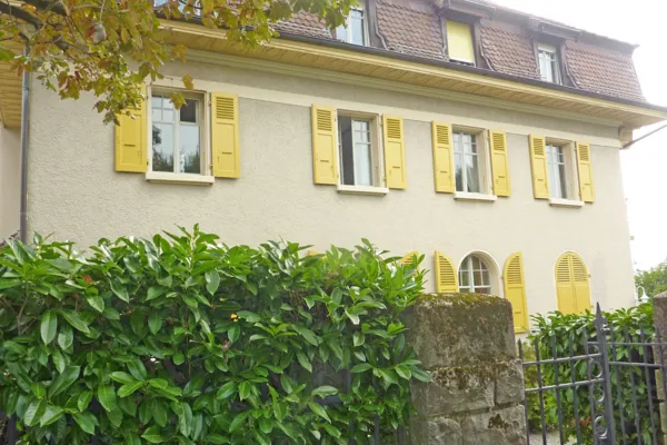 Fenêtres à petits bois encadrées de volets jaunes