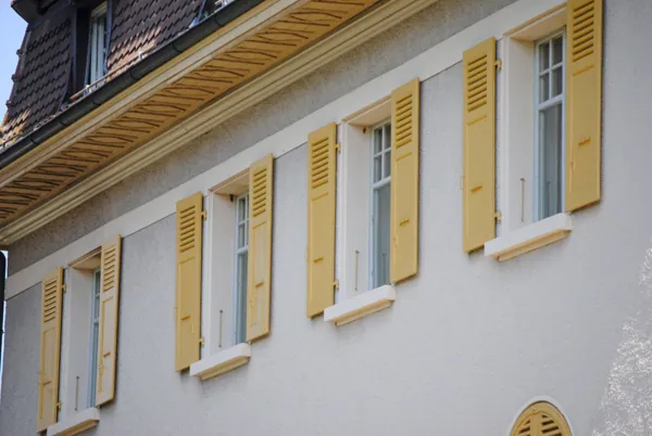 Maison blanche dont les volets ont été repeints en jaune
