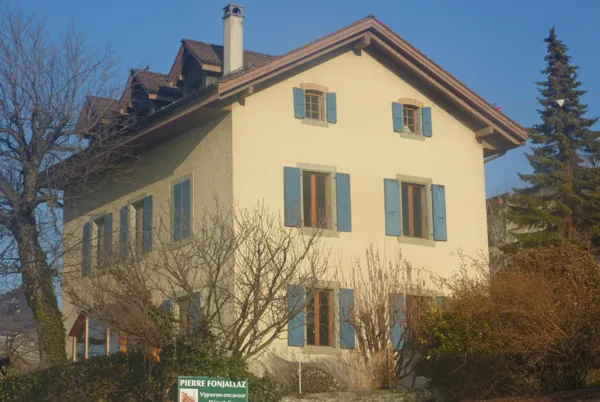 Volets verts restaurés sur une ancienne ferme jaune