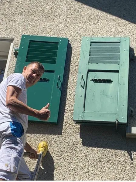 Paire de volets verts restaurés qui sèchent au sol